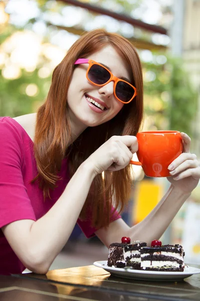 Estilo chica pelirroja con taza y pastel — Foto de Stock