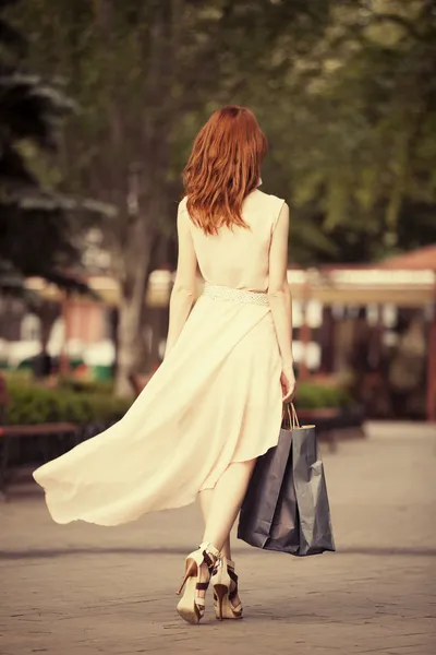 Junge Frau mit Einkaufstüten läuft auf der Straße der Stadt — Stockfoto