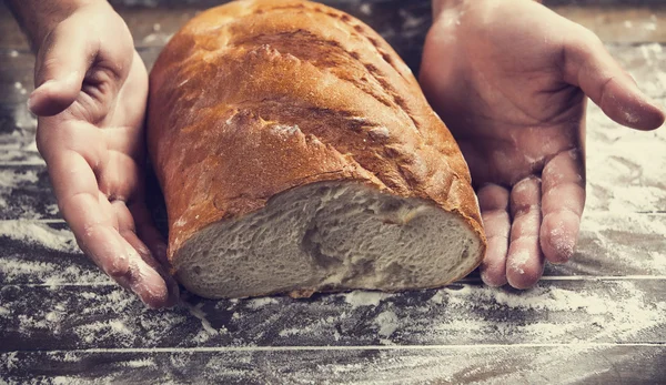 用面包的面包师的手 — 图库照片