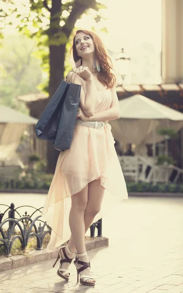 Молода жінка з сумками, що ходять по міській вулиці — стокове фото