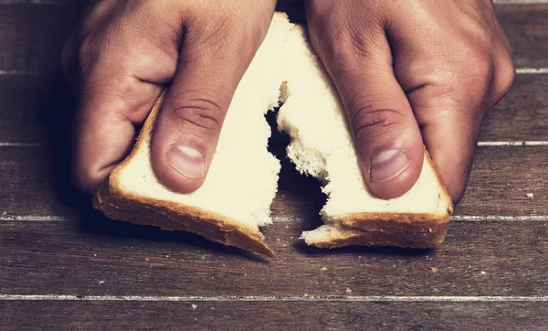 Ręcznie łamiąc bochenek chleba przed — Zdjęcie stockowe