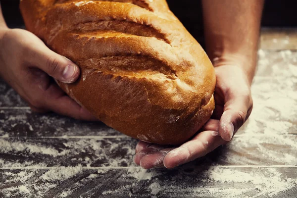 Les mains de Baker avec un pain — Photo