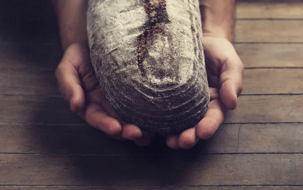 Bäckerhände mit Brot — Stockfoto