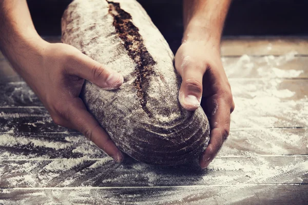 用面包的面包师的手 — 图库照片