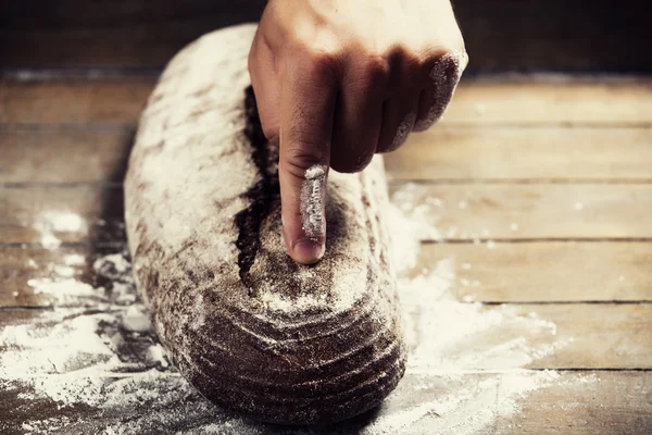 Baker's hands pointing on a bread. — Stock Photo, Image