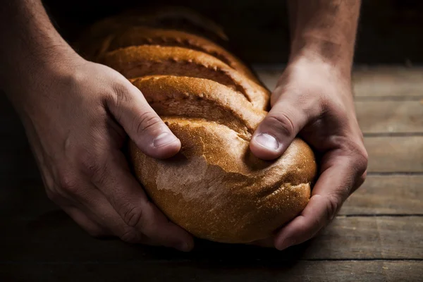 Baker's hands with a bread — Stock Photo, Image