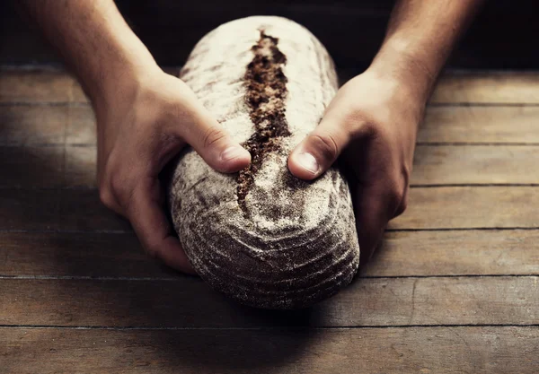 Baker's hands with a bread — Stock Photo, Image