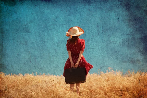 Рыжая девушка с чемоданом на открытом воздухе — стоковое фото