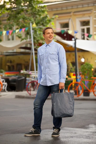 Hombre con bolsas de compras caminando al aire libre — Foto de Stock