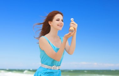 Kızıl saçlı kız sahilde parfüm