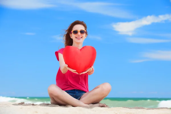 Redhead teen girl with heart shape on the beach — Stock Photo, Image