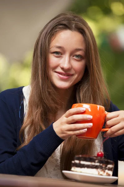 Estilo menina com bolo e xícara sentado no café — Fotografia de Stock