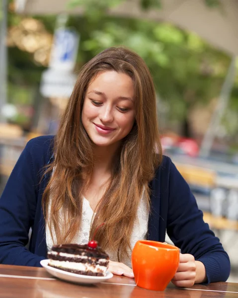 Stijl meisje met cake en beker zittend in het café — Stockfoto