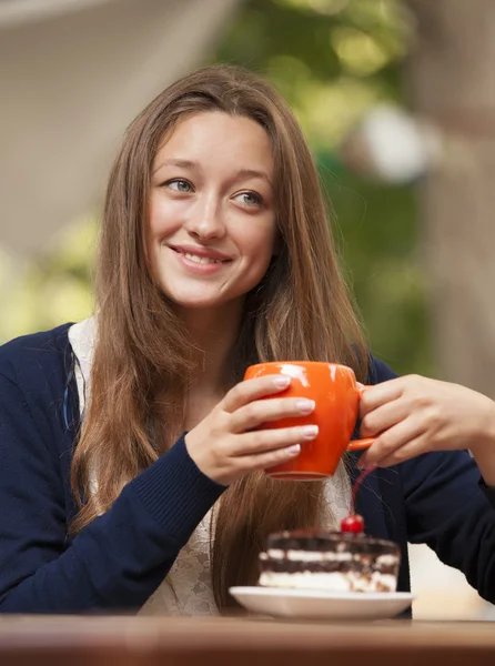 Stil flicka med tårta och kopp sitter i café — Stockfoto