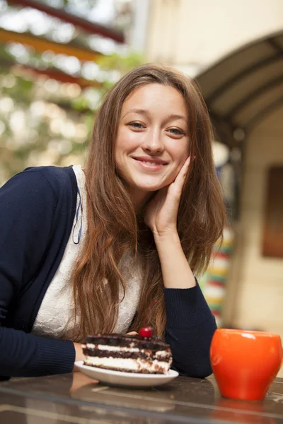 Mädchen mit Kuchen und Tasse im Café — Stockfoto