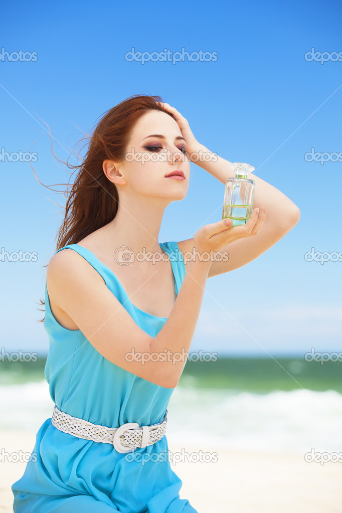 Redhead girl with perfume on the beach