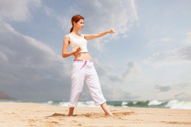atletik kadın kum Beach'te bir tekme gerçekleştirme