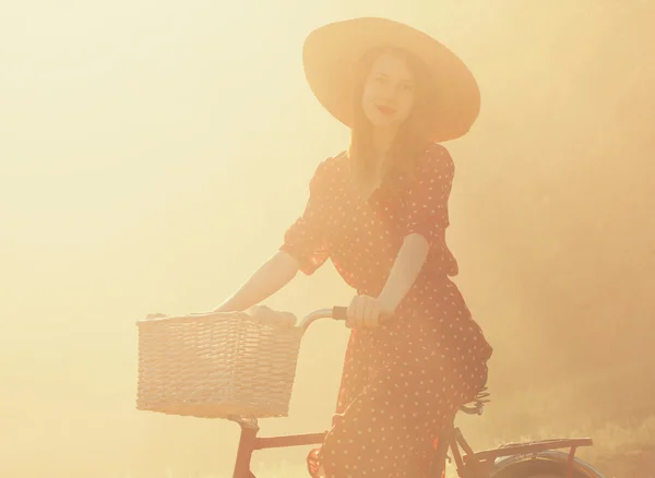 Flicka på cykel på landsbygden i soluppgång tid. — Stockfoto