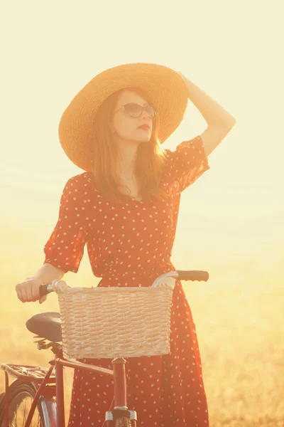 Girl on a bike in the countryside in sunrise time. — Stock Photo, Image