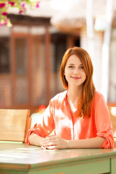 Stijl roodharige meisje zit in het café — Stockfoto