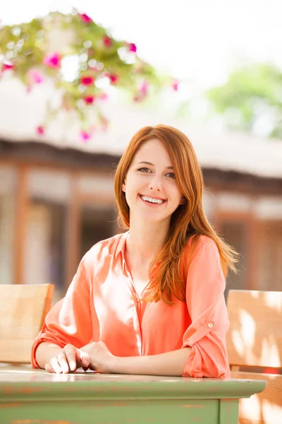 Estilo pelirroja chica sentada en la cafetería — Foto de Stock