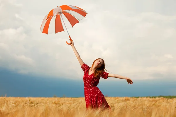 Ragazza rossa con ombrello sul campo — Foto Stock