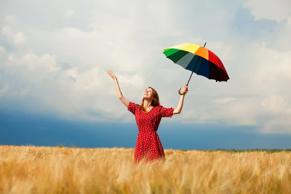 Ragazza rossa con ombrello sul campo — Foto Stock