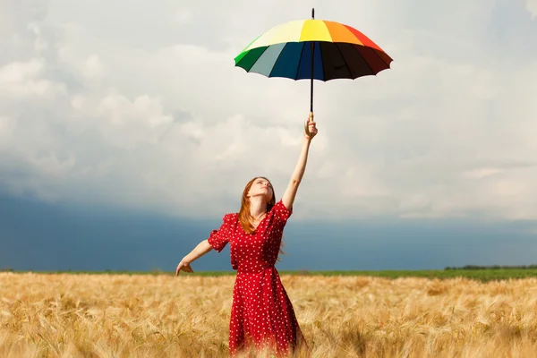 Ragazza rossa con ombrello sul campo — Foto Stock