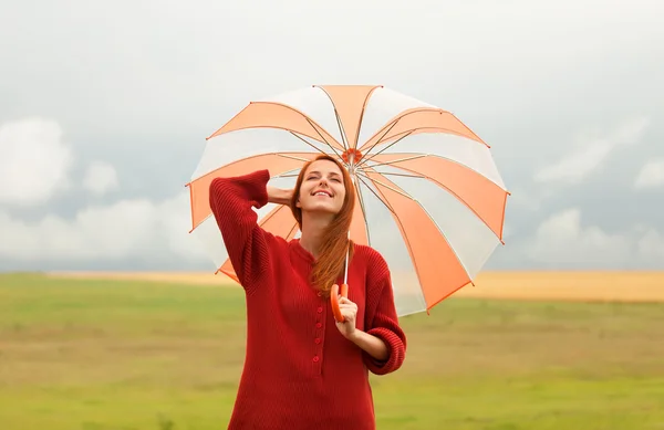 Redhead girl with umbrella at meadow — Stock Photo, Image