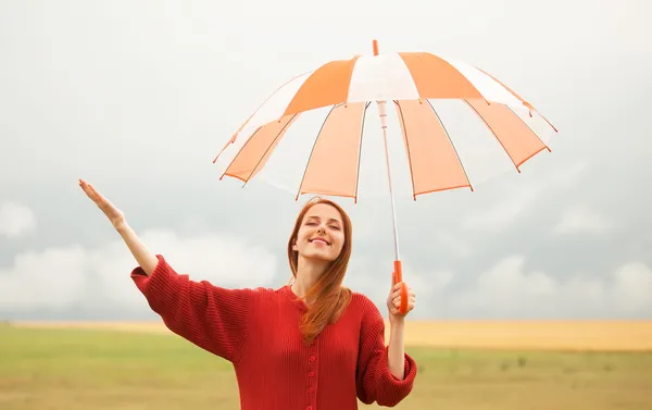 Ruiva menina com guarda-chuva no prado — Fotografia de Stock