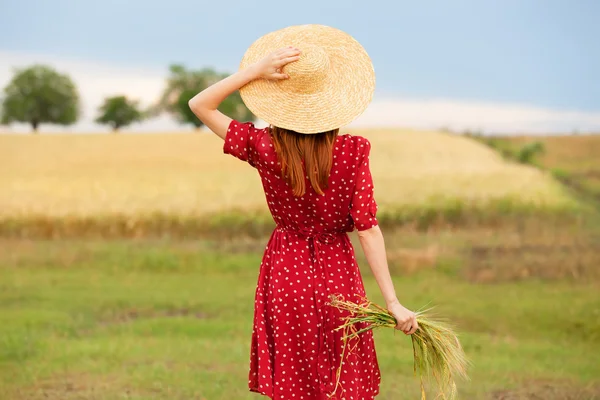 Redhead girl in red dress at wheat field — Stock Photo, Image