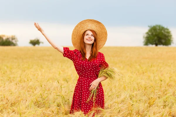 Redhead girl in red dress at wheat field — Stock Photo, Image