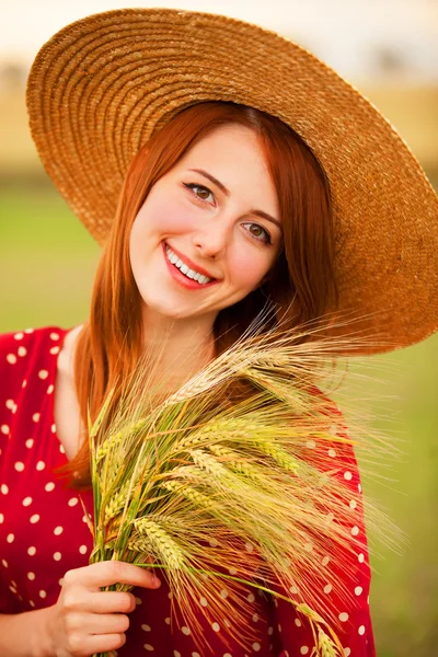 Redhead girl in red dress at wheat field — Stock Photo, Image