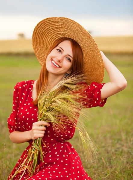 Fille rousse en robe rouge au champ de blé — Photo