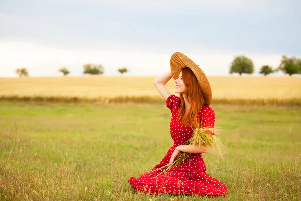 Fille rousse en robe rouge au champ de blé — Photo