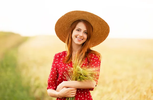 Menina ruiva em vestido vermelho no campo de trigo — Fotografia de Stock