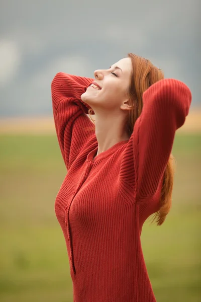 Rödhårig flicka på ängen nära vete fält — Stockfoto