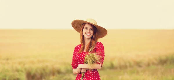 Fille rousse en robe rouge au champ de blé — Photo