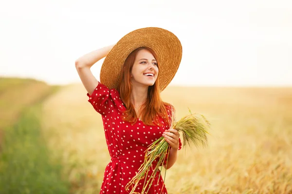 Fille rousse en robe rouge au champ de blé — Photo