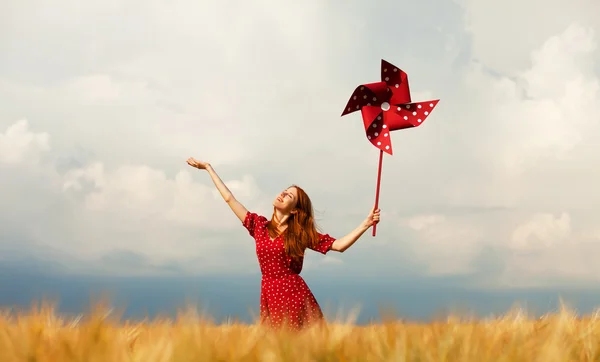 Ragazza rossa con turbina eolica giocattolo — Foto Stock