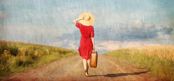 Рыжая девушка с чемоданом на открытом воздухе . — стоковое фото