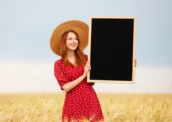 Menina ruiva com quadro-negro no campo de trigo — Fotografia de Stock