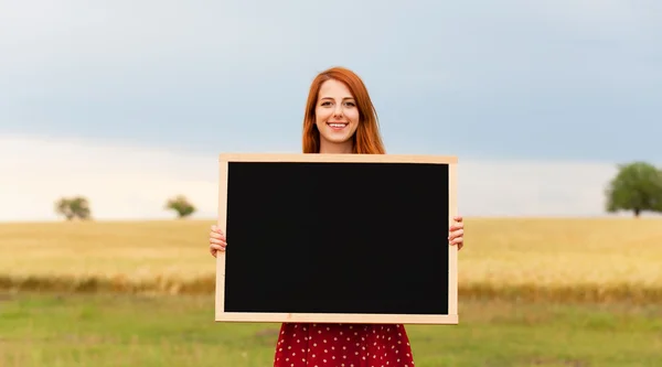 Ragazza rossa con lavagna al campo di grano — Foto Stock