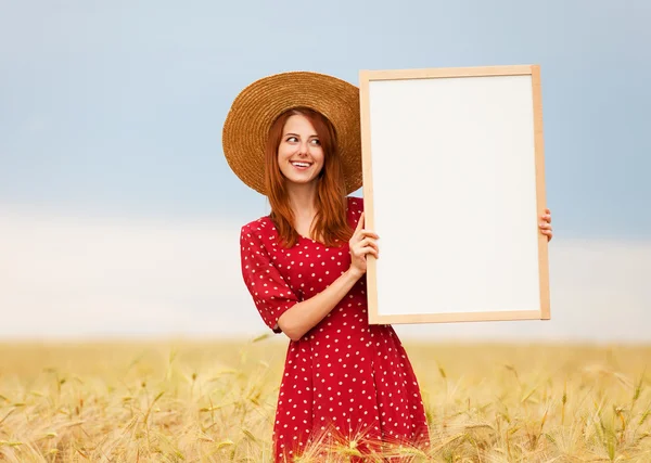 Menina ruiva com quadro-negro no campo de trigo — Fotografia de Stock