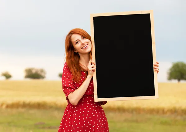 Redhead girl with blackboard at wheat field — Stock Photo, Image