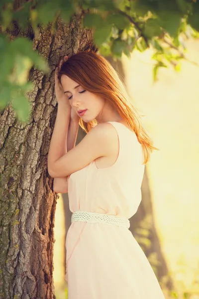 Рыжая девушка возле дерева в сельской местности — стоковое фото