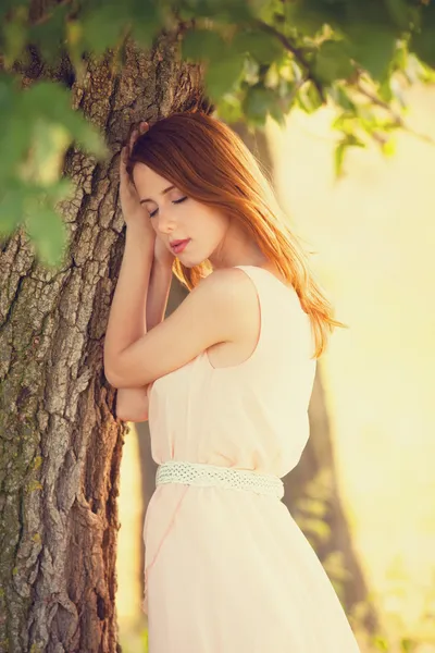 Pelirroja chica cerca de árbol en el campo — Foto de Stock