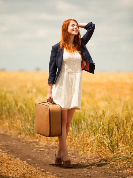 Roodharige meisje met koffer in buiten. — Stockfoto
