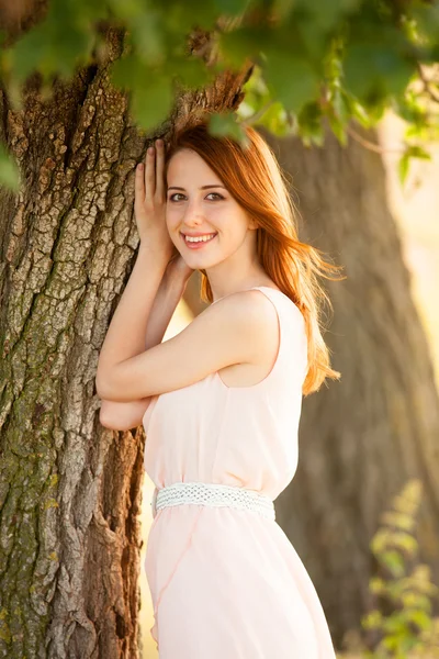 Redhead girl near tree at countryside — Stock Photo, Image