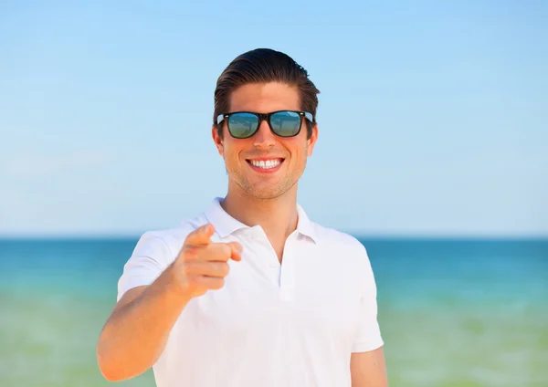 Knappe jonge man bij strand achtergrond — Stockfoto